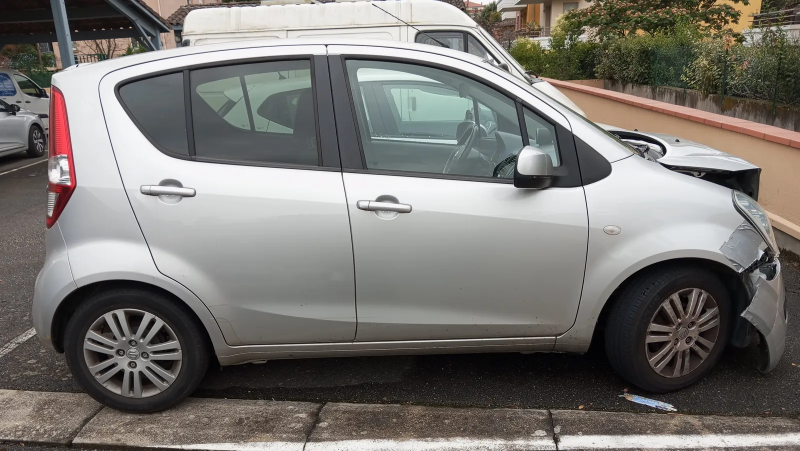 Opel Agila grise accidentée à l'avant droit, capot froissé et pare-chocs arraché